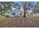 Large backyard with mature tree and leaf covered lawn at 6621 Bouganvillea Crescent Dr, Orlando, FL 32809