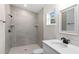 Bathroom with gray tile shower, white vanity, and a window at 258 Fraser Rd, Debary, FL 32713