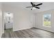 Bright bedroom with ceiling fan, an ensuite bathroom, and wood-look flooring at 258 Fraser Rd, Debary, FL 32713