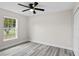 Well-lit bedroom with grey laminate flooring and a window with backyard view at 258 Fraser Rd, Debary, FL 32713