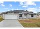 Newly built home showcasing gray exterior, white garage door, and stone accents at 258 Fraser Rd, Debary, FL 32713