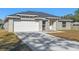 New home features gray siding, white garage door, and a stone accent wall at 258 Fraser Rd, Debary, FL 32713