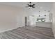 Open living area showcasing grey flooring, vaulted ceiling, and white kitchen at 258 Fraser Rd, Debary, FL 32713