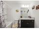 Cozy bathroom features tub with shower, single sink vanity, toilet and decorative wall art at 4694 Monica St, The Villages, FL 32163