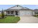 Charming single-story home with a two-car garage, a well-kept lawn, and manicured landscaping at 4694 Monica St, The Villages, FL 32163