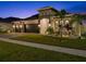 Well-manicured front yard and exterior of a home featuring a three-car garage and elegant architectural details at 489 Avila Pl, Howey In The Hills, FL 34737
