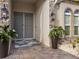 Inviting front entrance featuring a gray double door, lantern sconces, a decorative rug, and lush potted plants at 489 Avila Pl, Howey In The Hills, FL 34737