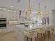 Bright kitchen featuring a large island with seating, pendant lighting, stainless steel appliances, and custom cabinetry at 489 Avila Pl, Howey In The Hills, FL 34737