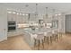 Bright kitchen featuring a large island, pendant lighting, stainless steel appliances, and light wood flooring at 489 Avila Pl, Howey In The Hills, FL 34737