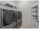 Modern laundry room equipped with LG Signature washer and dryer set, plus shelving and storage at 489 Avila Pl, Howey In The Hills, FL 34737