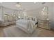 Expansive main bedroom with sitting area, padded headboard, mirrored nightstands, and stylish crystal chandelier at 489 Avila Pl, Howey In The Hills, FL 34737