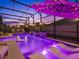 Inviting screened-in pool with lounge chairs, ambient lighting, and a soothing waterfall feature at 489 Avila Pl, Howey In The Hills, FL 34737