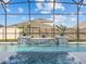 Close-up view of a gorgeous pool with water features, framed by the screened-in enclosure at 489 Avila Pl, Howey In The Hills, FL 34737