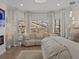 Bright sitting area in the main bedroom features a curved sofa and oversized windows with lots of natural light at 489 Avila Pl, Howey In The Hills, FL 34737