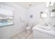 Clean bathroom with a white vanity, toilet, and a window view of the pool at 577 Sunridge Woods Blvd, Davenport, FL 33837