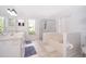 All-white bathroom featuring a soaking tub, separate shower, and double sink vanity at 577 Sunridge Woods Blvd, Davenport, FL 33837