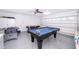 Finished garage with epoxy floor, ceiling fan, and a pool table for extra space at 577 Sunridge Woods Blvd, Davenport, FL 33837