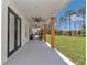 Long covered back porch with ceiling fans, swing chairs, and lawn views at 12009 Sw 61St Place Road, Ocala, FL 34481