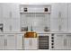 Close up of wet bar featuring a copper sink, wine fridge, custom cabinets, and wine glass rack at 12009 Sw 61St Place Road, Ocala, FL 34481