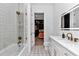Stylish bathroom with a tub, shower, decorative tile floors, white vanity, and a modern backlit mirror at 12009 Sw 61St Place Road, Ocala, FL 34481
