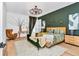 Stylish bedroom with wood floors, a unique chandelier, and a green accent wall, creating a comfortable and inviting space at 12009 Sw 61St Place Road, Ocala, FL 34481
