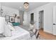 Well-lit bedroom with a decorative chandelier, luxury bedding, and a glimpse into the bathroom at 12009 Sw 61St Place Road, Ocala, FL 34481