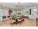 Bright, open dining area with modern lighting, seating for eight, and an open view to the kitchen at 12009 Sw 61St Place Road, Ocala, FL 34481