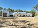 Exterior view of a charming modern farmhouse with a detached garage on a large lot, and blue skies at 12009 Sw 61St Place Road, Ocala, FL 34481
