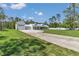 Beautiful home featuring a pristine white exterior, complemented by lush green lawns and a concrete driveway at 12009 Sw 61St Place Road, Ocala, FL 34481
