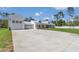 Large driveway leading to a white farmhouse with a detached two car garage at 12009 Sw 61St Place Road, Ocala, FL 34481