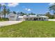Spacious white farmhouse with a detached garage, metal roof, and sprawling green lawn at 12009 Sw 61St Place Road, Ocala, FL 34481