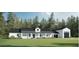 Exterior view of a modern farmhouse with a detached garage and covered entry on a well-manicured lawn at 12009 Sw 61St Place Road, Ocala, FL 34481