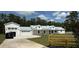 Stunning exterior view of a modern farmhouse with a well-manicured lawn and a long private driveway at 12009 Sw 61St Place Road, Ocala, FL 34481