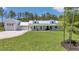 A sprawling white farmhouse with a metal roof and large garage offers country charm at 12009 Sw 61St Place Road, Ocala, FL 34481