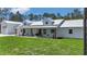Charming farmhouse with a metal roof, welcoming front porch, and spacious lawn at 12009 Sw 61St Place Road, Ocala, FL 34481
