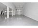 Expansive three car garage featuring multiple access points and a clean, painted floor at 12009 Sw 61St Place Road, Ocala, FL 34481