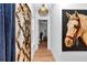 Hallway features chandelier, decorative gold mirror and horse artwork at 12009 Sw 61St Place Road, Ocala, FL 34481