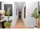 A long hallway with hardwood floors, white walls, art decorations, and recessed lighting at 12009 Sw 61St Place Road, Ocala, FL 34481
