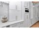 A bright white kitchen is designed with modern cabinetry, stone countertops, and gold accents at 12009 Sw 61St Place Road, Ocala, FL 34481
