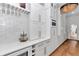 The kitchen boasts custom cabinets, stone countertops, gold hardware, and a beverage cooler at 12009 Sw 61St Place Road, Ocala, FL 34481