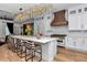 Well-appointed kitchen featuring a large island with seating, ample white cabinetry, and modern stainless steel appliances at 12009 Sw 61St Place Road, Ocala, FL 34481