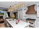 Designer kitchen with white cabinetry, brass hardware, and modern light fixture at 12009 Sw 61St Place Road, Ocala, FL 34481