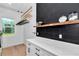 Bright laundry room with shiplap walls, black tile backsplash, sleek countertops, and a view to the outdoors at 12009 Sw 61St Place Road, Ocala, FL 34481