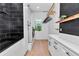 Modern laundry room with dark tile, shiplap, and white cabinets featuring high-end washer and dryer at 12009 Sw 61St Place Road, Ocala, FL 34481