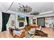 The living room features windmill fans, hardwood floors, leather furniture, and a stone fireplace at 12009 Sw 61St Place Road, Ocala, FL 34481
