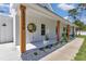 Welcoming front porch with wooden support columns and manicured garden beds at 12009 Sw 61St Place Road, Ocala, FL 34481