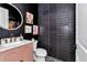 Chic powder room featuring designer tile, a pink vanity, black walls, and modern fixtures, creating a unique space at 12009 Sw 61St Place Road, Ocala, FL 34481