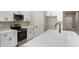 Well-lit kitchen with stainless steel appliances, white cabinets, and white speckled countertops at 9665 Sw 125 Ter, Dunnellon, FL 34432