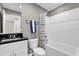 Well-lit bathroom with a shower-tub combination and a dark granite-topped vanity at 4457 Le Reve Ct, Kissimmee, FL 34746