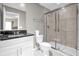 Modern bathroom with glass enclosed shower, granite vanity top and ample lighting at 4457 Le Reve Ct, Kissimmee, FL 34746